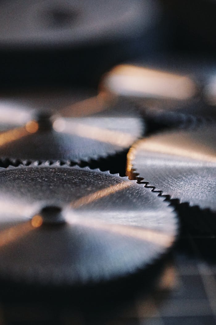 Detailed view of silver metallic gears in an industrial environment, showcasing precision and engineering.