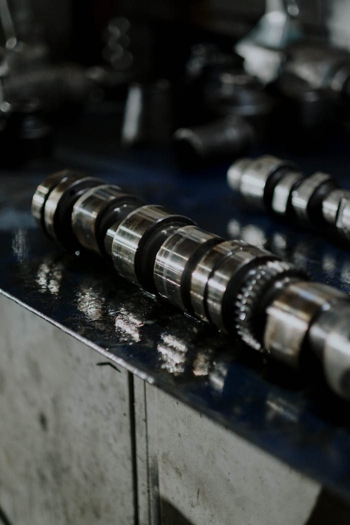 Detailed shot of a metal camshaft on a workbench, perfect for automotive industry themes.